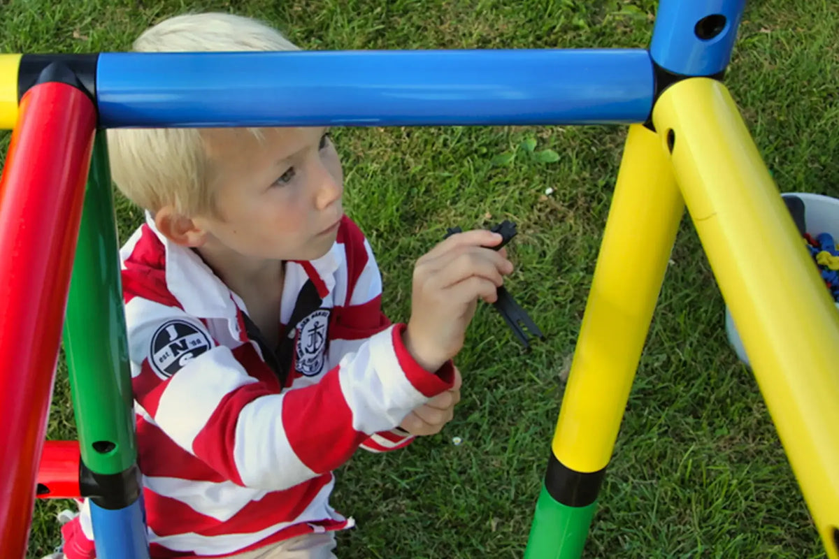 Child fastening a connector on a colourful QUADRO climbing frame