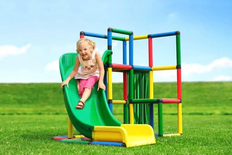 Child sliding down a green curved slide attached to a QUADRO tower