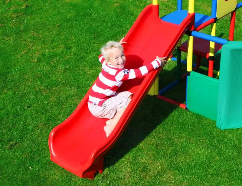 Toddler climbing up the red integrated slide on a QUADRO play tower