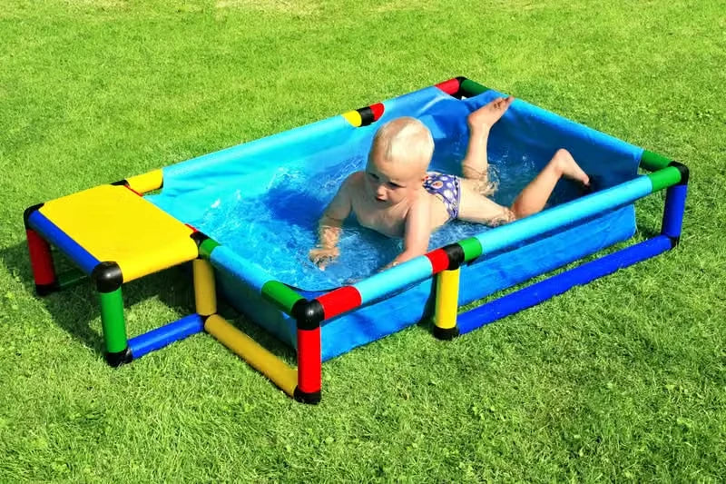 Baby crawling through water in a small rectangular blue QUADRO pool